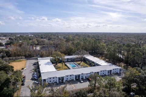Large white building with a pool in the middle of it.