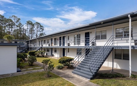 White building with a staircase leading to the second floor.