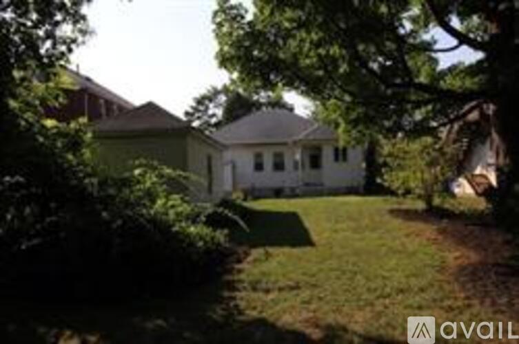A white house with a green lawn in front.