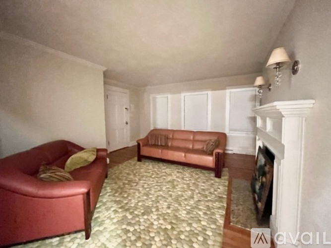 A living room with a red couch and a brown couch.