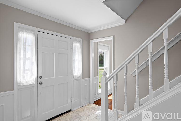 A hallway with a staircase and two doors.