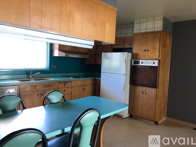A kitchen with a table and chairs and a refrigerator.