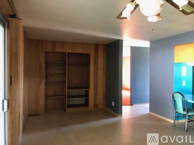 A room with a wooden cabinet and a blue chair.