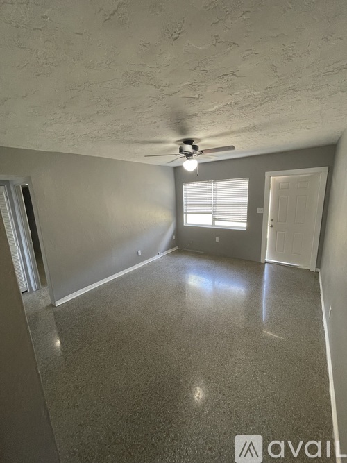 A room with a ceiling fan and a door.