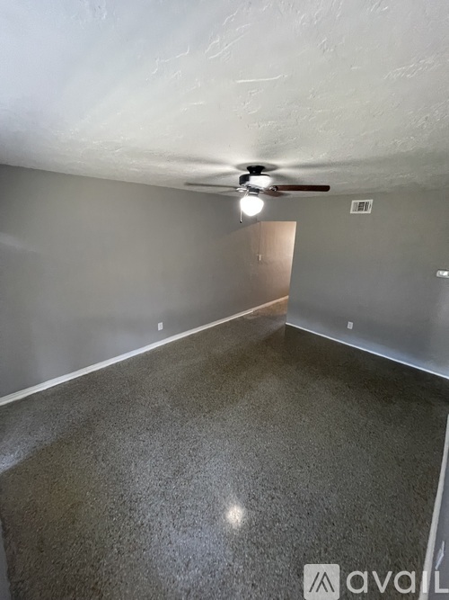 A room with a ceiling fan and a light fixture.