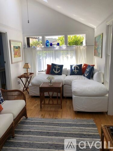 A living room with a white couch and a wooden coffee table.