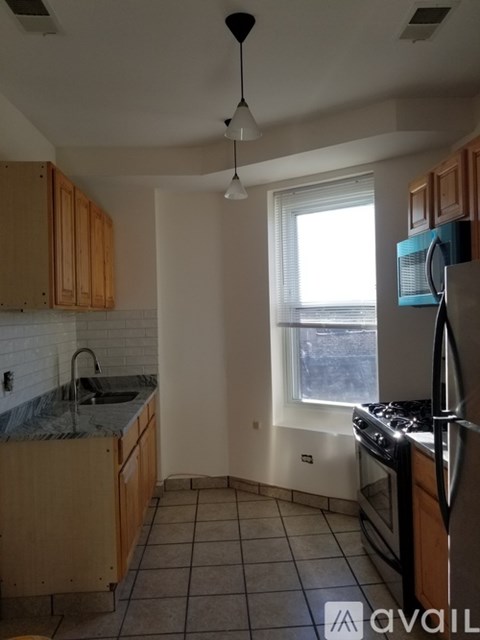 A kitchen with wooden cabinets and a black stove top oven.