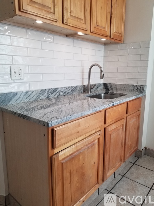 A kitchen with wooden cabinets and a marble countertop.