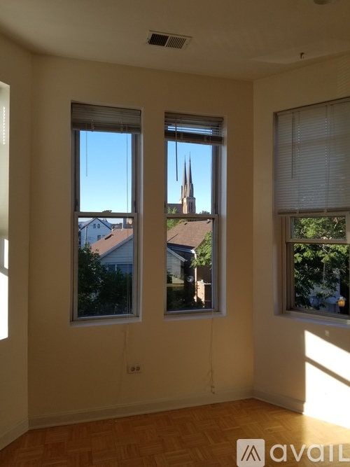 A room with two windows overlooking a residential area.