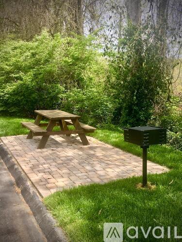 A picnic table is set up on a brick path in a grassy area.