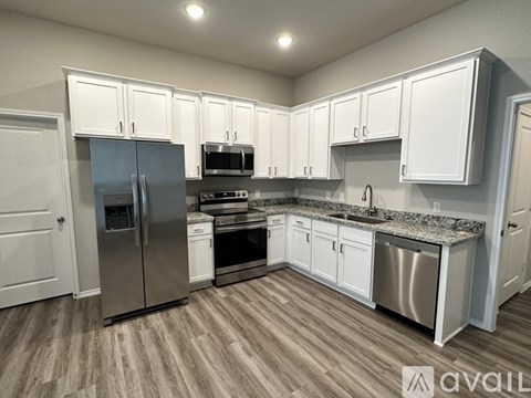 A kitchen with white cabinets and stainless steel appliances.