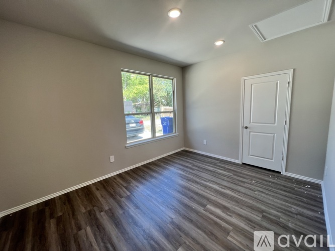 A room with wooden flooring and a white door.