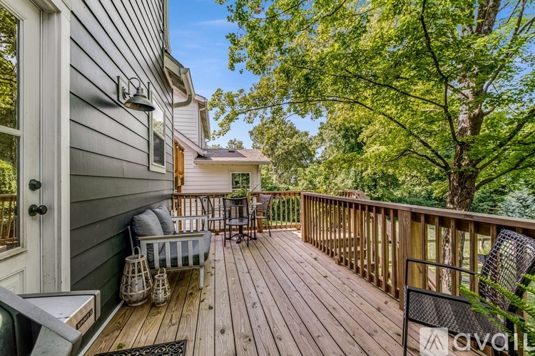 A wooden deck with a table and chairs is surrounded by trees.