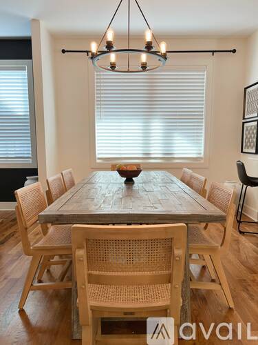 A dining room with a wooden table and chairs.