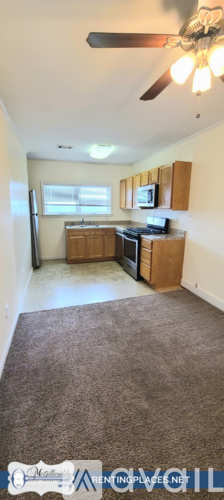 A kitchen with a refrigerator, microwave, and oven.