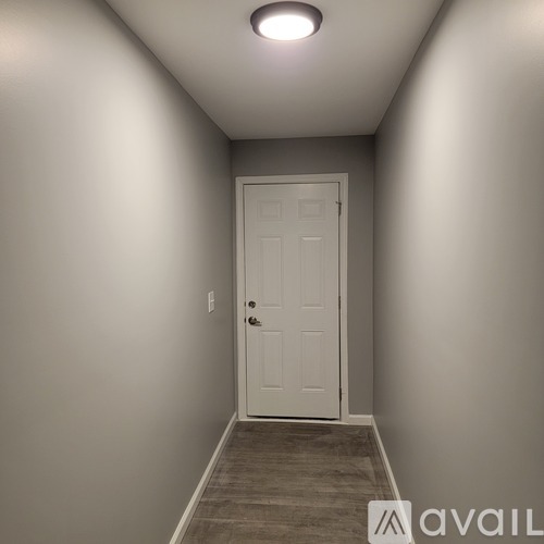 A white door is at the end of a hallway.