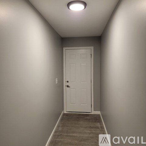 A white door is at the end of a hallway.