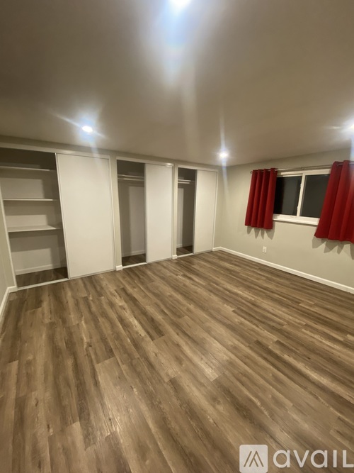 A room with wooden flooring and white walls.