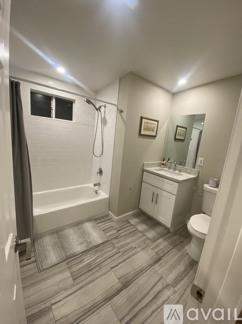 A bathroom with a tub, toilet, and sink.