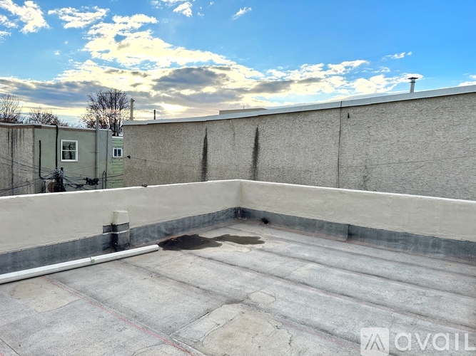 A rooftop with a flat surface and a small pool of water.