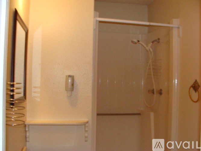A white bathroom with a towel rack and a mirror.