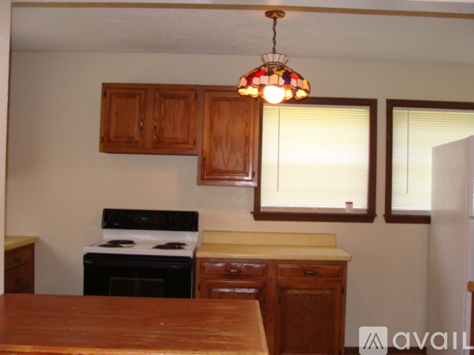 A kitchen with wooden cabinets and a stove top oven.
