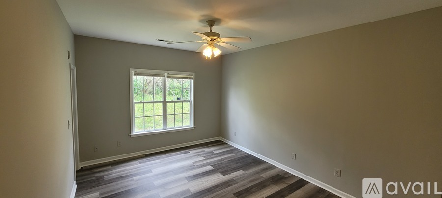A room with a window and a ceiling fan.