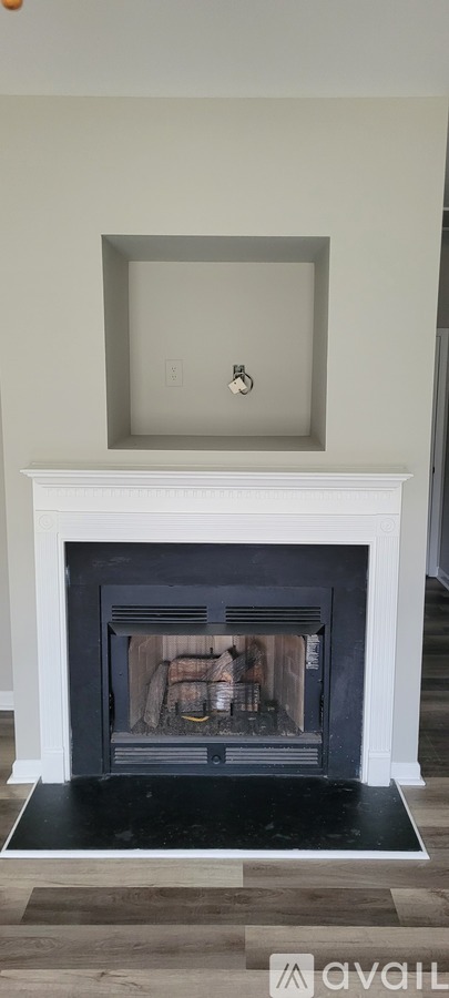 A fireplace with a white mantle and a black hearth.