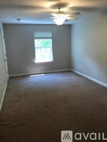 A room with a carpeted floor and a window.