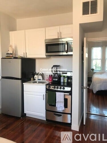A kitchen with white cabinets and a stove top oven.