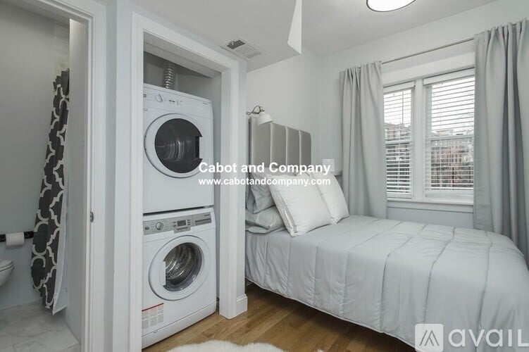 A small bedroom with a washing machine built into the wall.