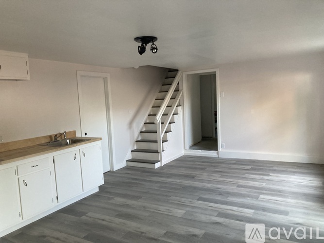 A room with a staircase and a sink.