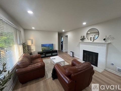A living room with a fireplace and a painting on the wall.