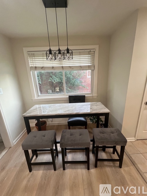 A dining room with a table and four chairs.