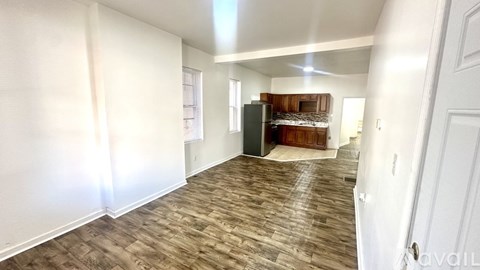A room with wooden flooring and white walls.