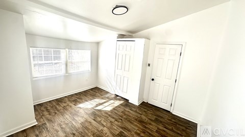 A room with white walls and a wooden floor.
