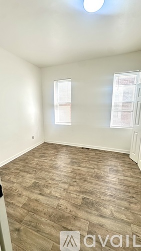 A room with wooden flooring and a window.