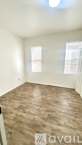 A room with wooden flooring and a window.