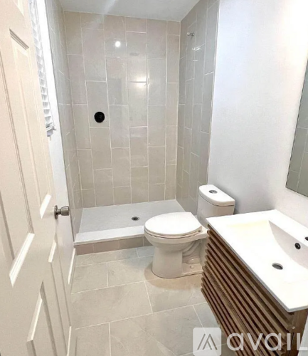 A white toilet sits next to a white sink in a bathroom.