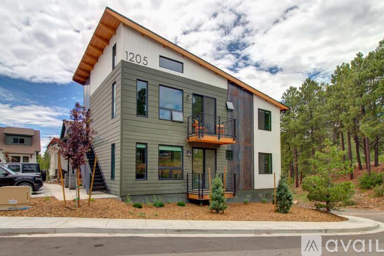 A modern house with a balcony and a garage door.