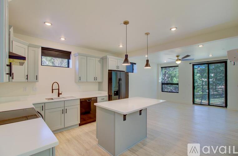 A kitchen with white cabinets and a large island in the middle.