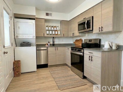 A kitchen with a white fridge, stainless steel dishwasher, and black stove top oven.