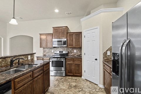 A kitchen with a refrigerator on the right side.