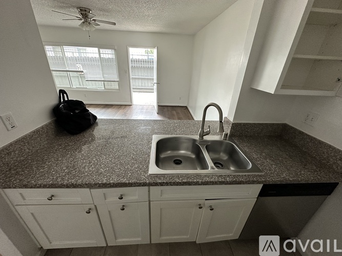 A kitchen with a sink and a fan.