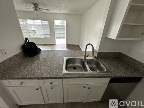 A kitchen with a sink and a fan.