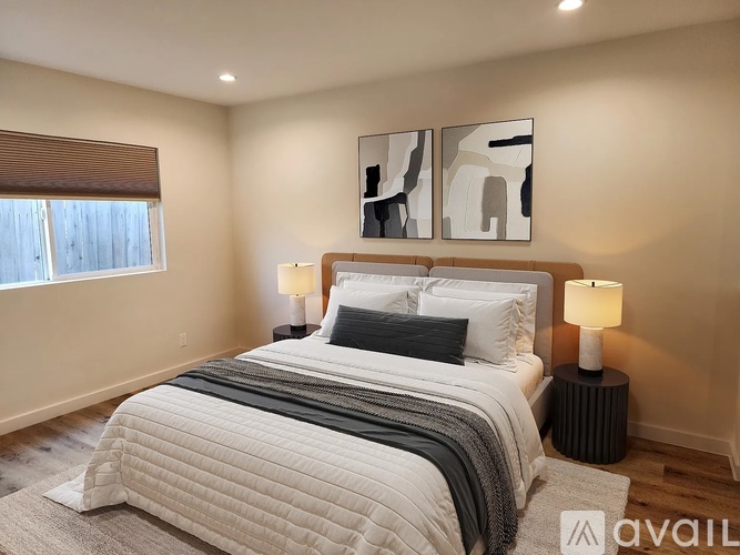 A bedroom with a large bed and two lamps.