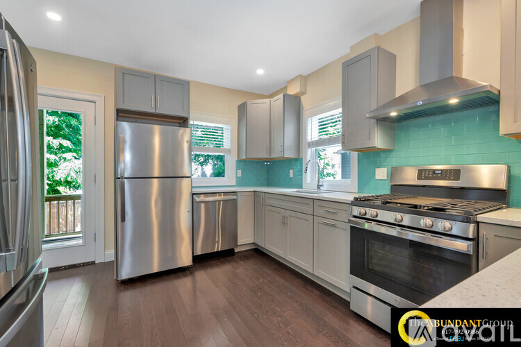 A kitchen with a stainless steel refrigerator and oven.