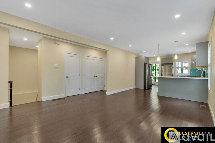 A spacious room with wooden floors and white doors.