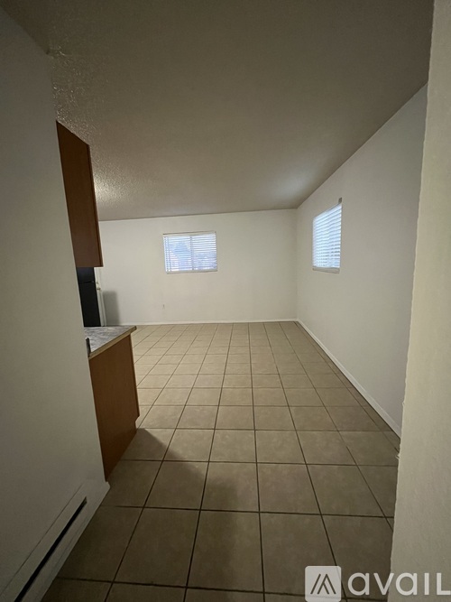 A room with tiled flooring and a window with blinds.