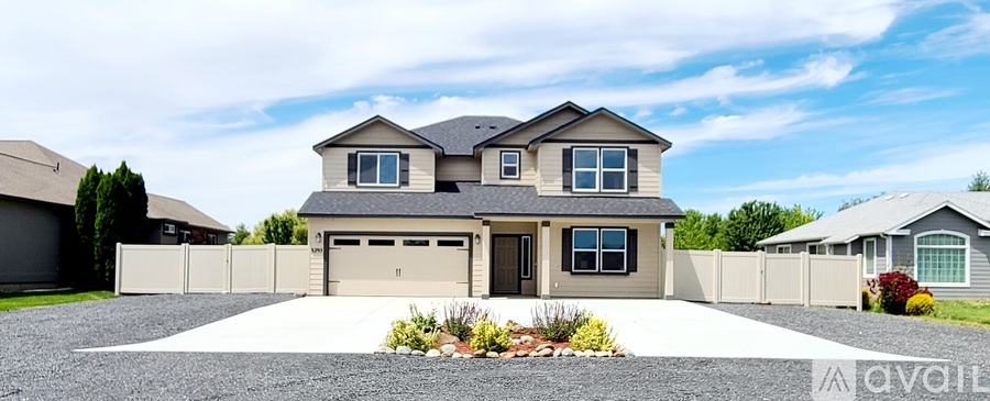 A modern house with a large front yard and a driveway.